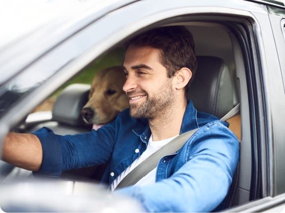 Man driving in car with his dog auto insurance