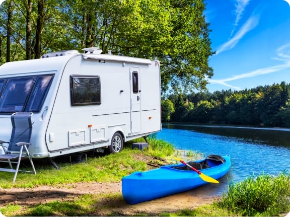 camper and kayak by a lake recreational vehicle insurance